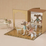 Stuffed animal mice in a staged setting with furniture and a box.