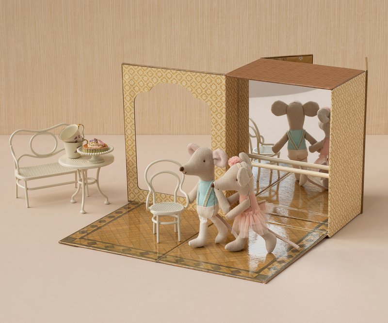 Stuffed animal mice in a staged setting with furniture and a box.