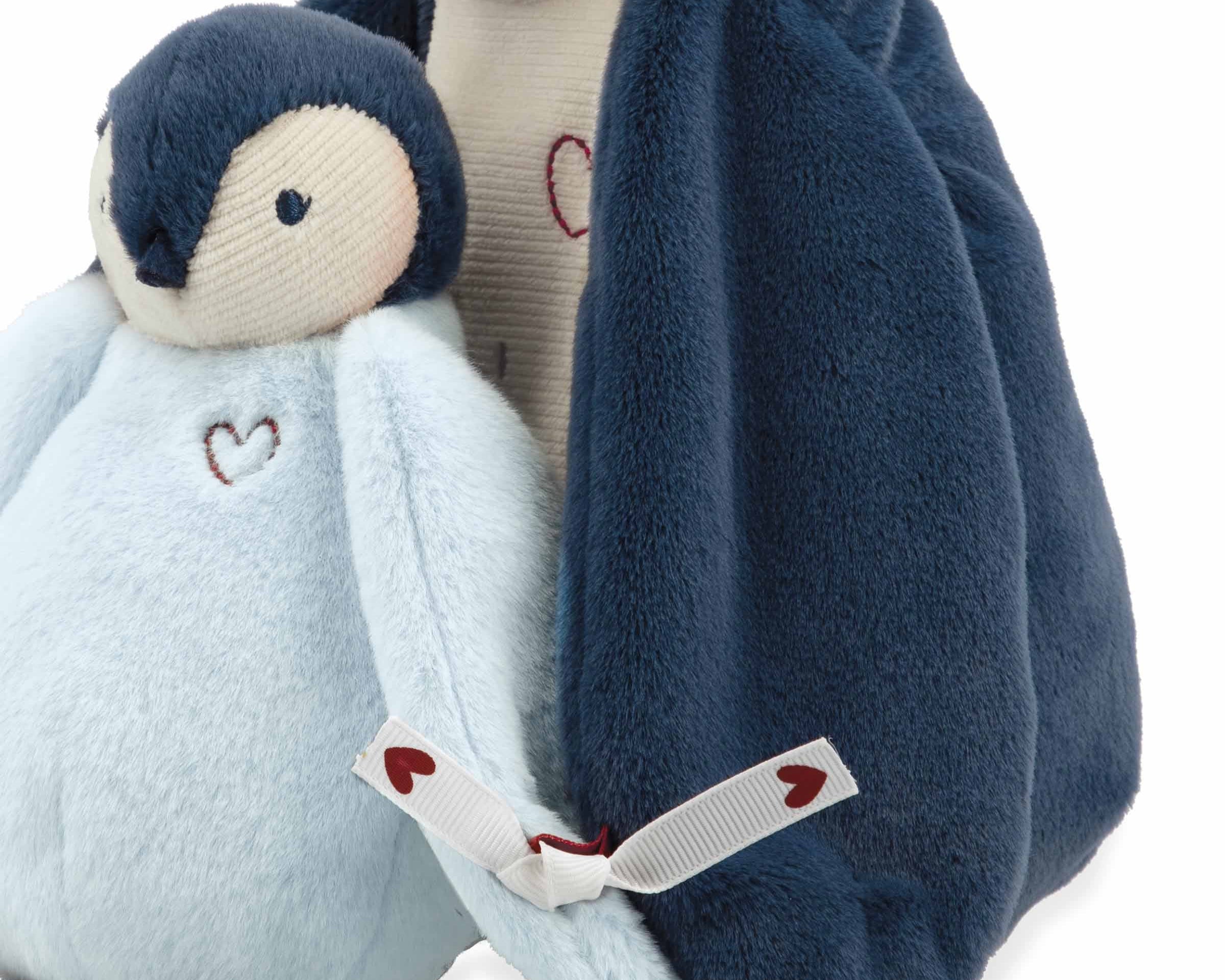 Plush penguin toy with a heart design on a white background