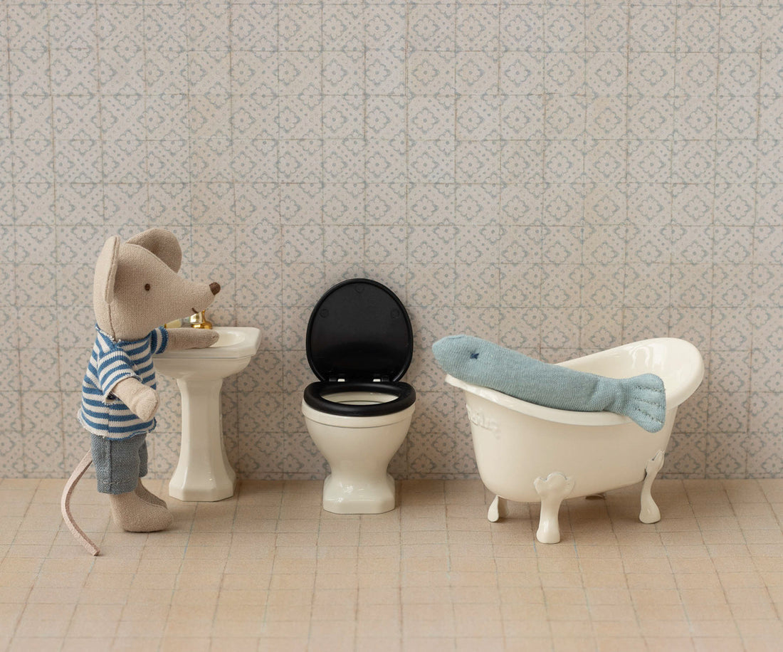Stuffed mouse and fish in a bathroom scene with miniature sink, wc and bath